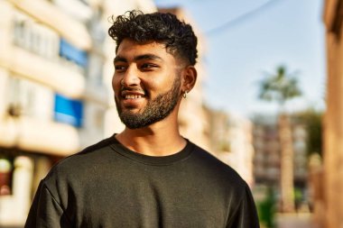 Sokakta kendinden emin gülümseyen genç bir Arap.