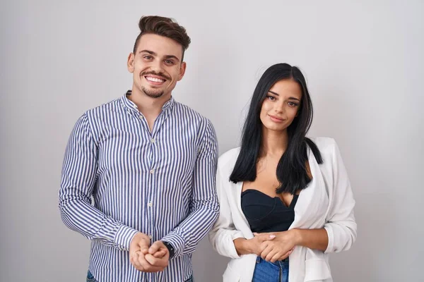 Young Hispanic Couple Standing White Background Hands Together Crossed Fingers — Stockfoto