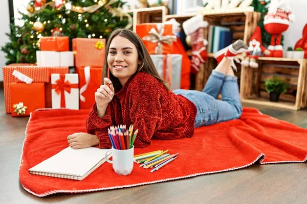 Mladý Hispánec Dívka Kreslení Notebook Ležící Vánočního Stromečku Doma — Stock fotografie