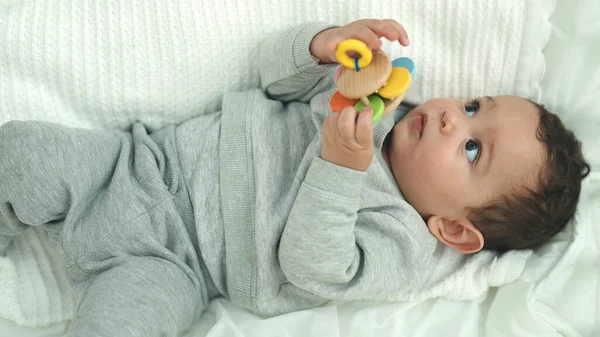 Sevimli Spanyol Bebek Yatakta Uzanmış Yatak Odasında Oyuncaklarla Oynuyor — Stok fotoğraf