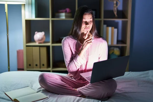 Young Hispanic Woman Using Computer Laptop Bed Thinking Concentrated Doubt —  Fotos de Stock