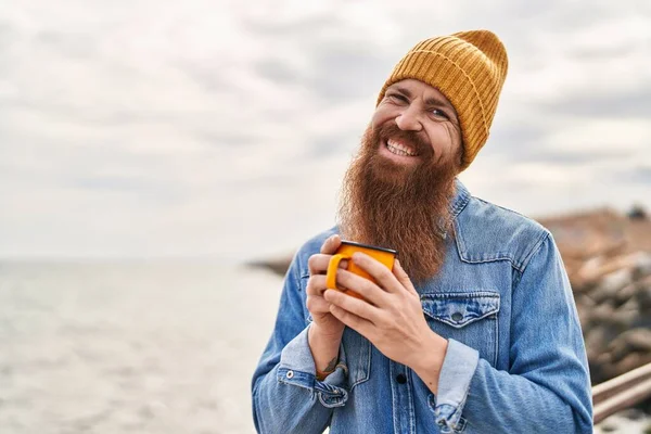 Young Redhead Man Smiling Confident Drinking Cup Coffee Seaside — Stock fotografie