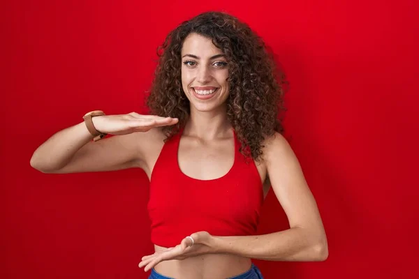 Hispanic Woman Curly Hair Standing Red Background Gesturing Hands Showing — Stock Photo, Image