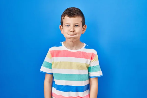 Young Caucasian Kid Standing Blue Background Puffing Cheeks Funny Face — Stockfoto