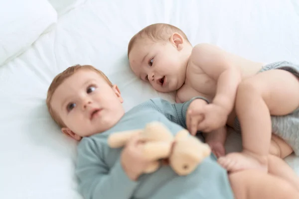 Два Малыша Лежат Кровати Играют Плюшевым Мишкой Спальне — стоковое фото
