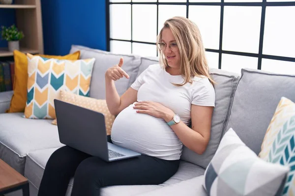 Νεαρή Έγκυος Γυναίκα Κάθεται Στον Καναπέ Στο Σπίτι Χρησιμοποιώντας Φορητό — Φωτογραφία Αρχείου