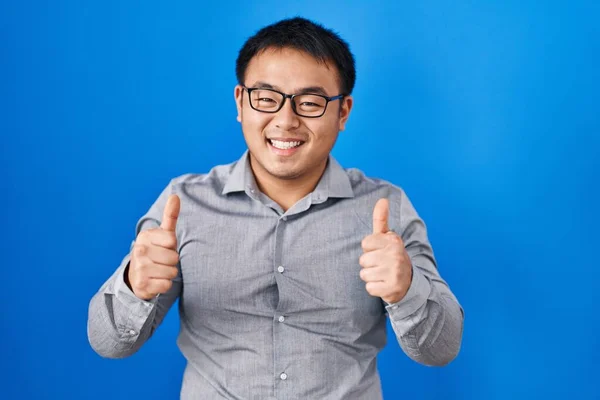 Jeune Homme Chinois Debout Sur Fond Bleu Signe Succès Faisant — Photo