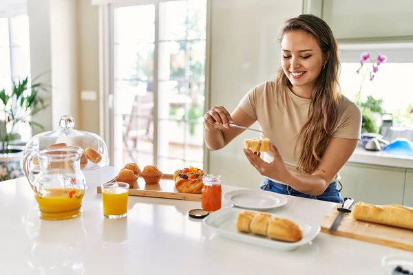 年轻美丽的惊慌失措的女人在厨房准备早餐 在面包上涂果酱 — 图库照片