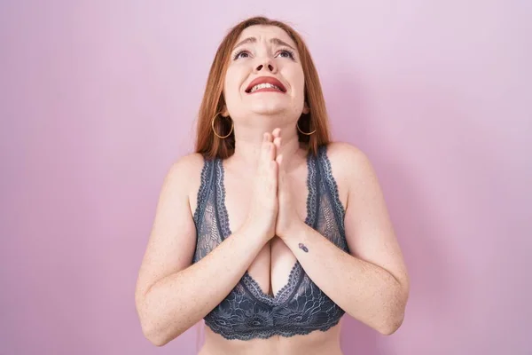 Redhead Woman Wearing Lingerie Pink Background Begging Praying Hands Together — Zdjęcie stockowe