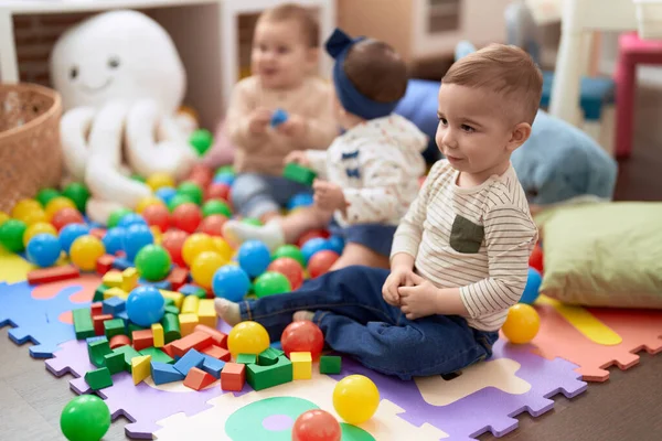 幼稚園の床に座っておもちゃで遊んでいる幼児のグループ — ストック写真