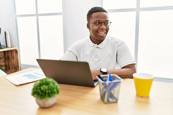 Νεαρός Αφρικανός Που Εργάζεται Στο Γραφείο Χρησιμοποιώντας Φορητό Υπολογιστή Κοιτάζοντας — Φωτογραφία Αρχείου