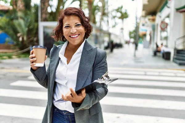 Lateinamerikanische Geschäftsfrau Mittleren Alters Trinkt Kaffee Und Hält Klemmbrett Der — Stockfoto