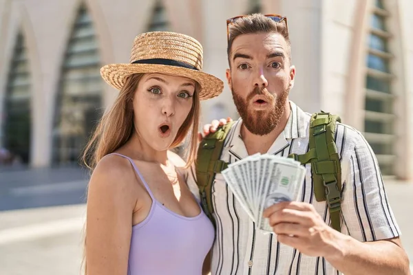 Young Tourist Couple Holding Dollars Banknotes Scared Amazed Open Mouth — Stock Photo, Image