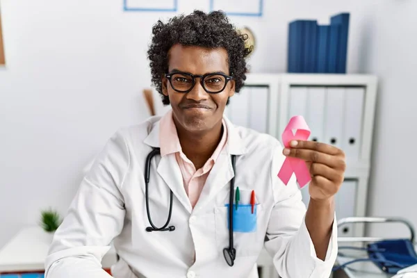 African Doctor Man Holding Pink Cancer Ribbon Looking Positive Happy — Stock Photo, Image