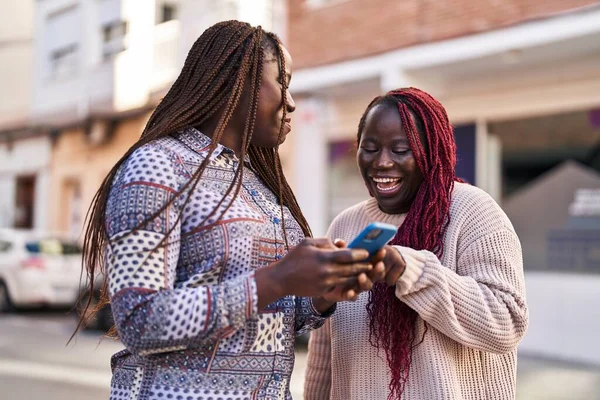 Mujeres Afroamericanas Amigas Sonriendo Confiadas Usando Smartphone Calle —  Fotos de Stock