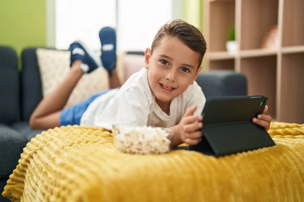 Adorável Criança Hispânica Assistindo Vídeo Touchpad Deitado Sofá Casa — Fotografia de Stock