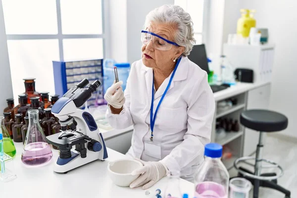 Ηλικιωμένη Γκριζομάλλα Γυναίκα Φορώντας Στολή Επιστήμονα Κρατώντας Χάπι Στο Εργαστήριο — Φωτογραφία Αρχείου