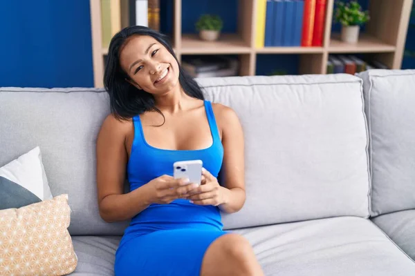 Mujer Latina Hermosa Joven Usando Teléfono Inteligente Sentado Sofá Casa —  Fotos de Stock