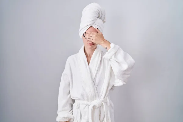 金发女人穿着浴衣 用手捂住眼睛 看起来严肃而忧郁 躲藏和拒绝的概念 — 图库照片