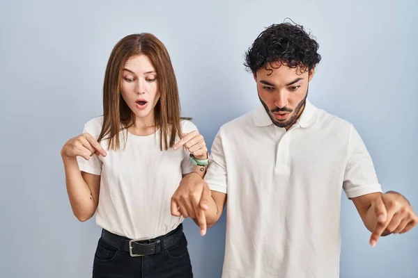 Gündelik Giysiler Giymiş Genç Bir Çift Parmaklarıyla Işaret Ediyor Reklam — Stok fotoğraf