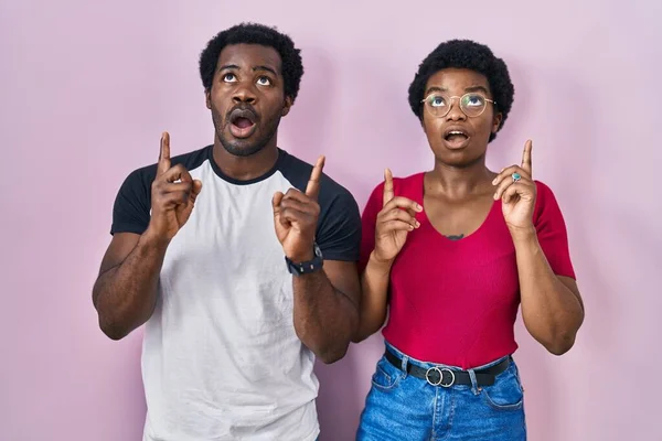 Genç Afro Amerikan Çift Pembe Arka Planda Durup Hayret Şaşkınlık — Stok fotoğraf