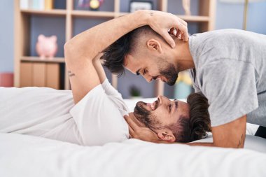 Young couple hugging each other lying on bed at bedrooom