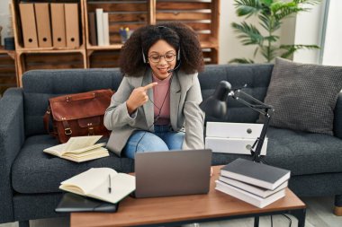 Young african american woman doing online session at consultation office smiling happy pointing with hand and finger 
