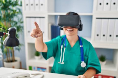 Genç, güzel İspanyol kadın doktor klinikte sanal gerçeklik gözlüğü kullanıyor.