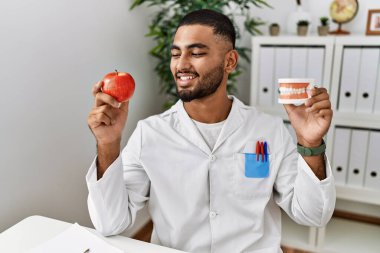 Diyetisyen üniformalı genç bir Arap klinikte sağlıklı beslenme talep ediyor.
