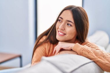 Evdeki kanepede oturan kendine güvenen güzel İspanyol kadın.