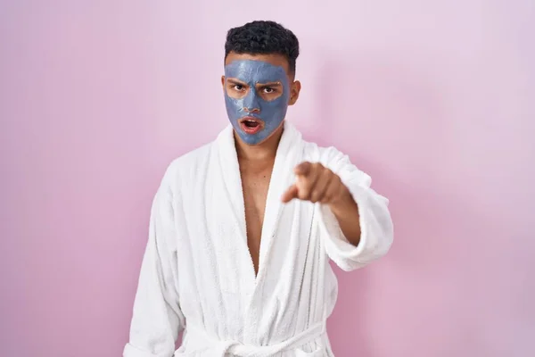 Young Hispanic Man Wearing Beauty Face Mask Bath Robe Pointing — 图库照片
