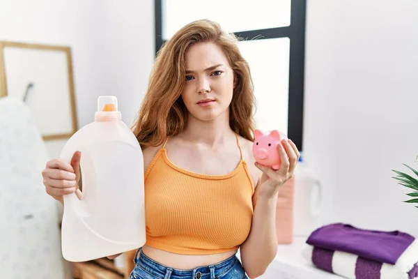 Jonge Blanke Vrouw Met Detergent Fles Spaarvarken Bank Sceptisch Nerveus — Stockfoto