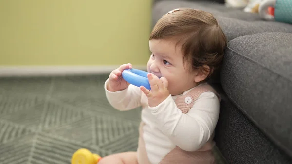 Adorable Toddler Bitting Plastic Hoop Sitting Floor Home — Zdjęcie stockowe