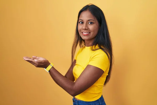 Mladá Indiánská Žena Stojící Nad Žlutým Pozadím Ukazuje Stranou Rukama — Stock fotografie