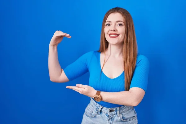 Redhead Woman Standing Blue Background Gesturing Hands Showing Big Large — Stock fotografie