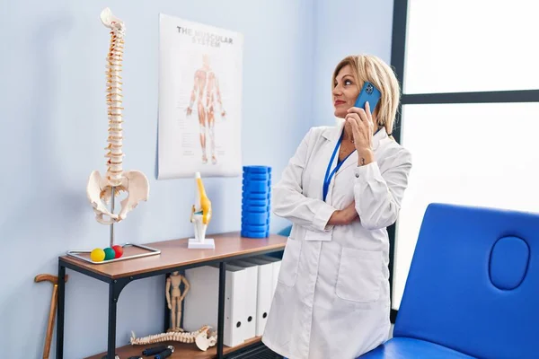 Middle Age Blonde Woman Wearing Physiotherapist Uniform Talking Smartphone Physiotherapy — Fotografia de Stock