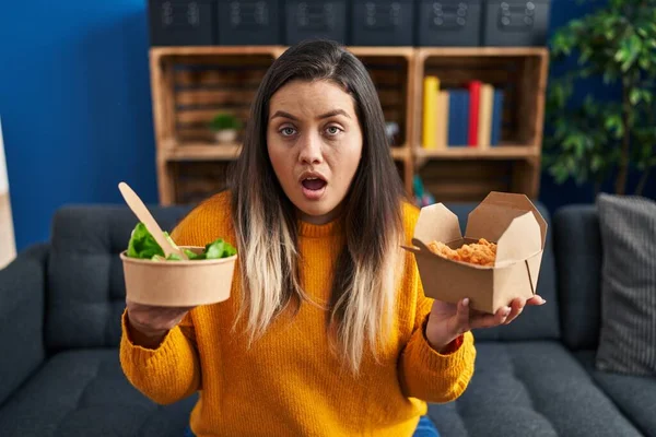 Young Hispanic Woman Holding Healthy Salad Fried Chicken Wings Shock — Stockfoto