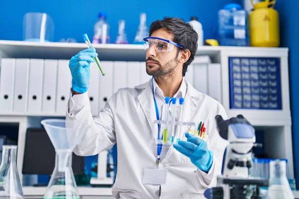 Laboratuvarda test tüpleri tutan genç İspanyol bilim adamı.