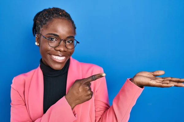 Schöne Schwarze Frau Steht Über Blauem Hintergrund Erstaunt Und Lächelt — Stockfoto