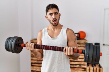 Şok suratlı, kuşkucu ve alaycı bakışlı ağzı açık, ağzı açık ve şaşırmış genç İspanyol bir adam. 