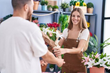 Man and woman customer buying bouquet of flowers at flower shop