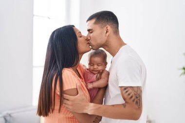 Hispanic family hugging each other kissing at home