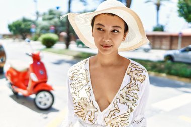 Sokakta kendinden emin gülümseyen genç İspanyol kadın.