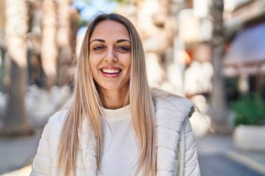 Sokakta kendinden emin gülümseyen genç bir kadın