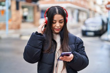 Genç, güzel, İspanyol bir kadın. Kendine güvenen, sokakta müzik dinleyen.
