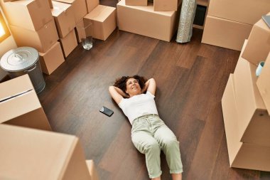 Orta yaşlı İspanyol kadın yeni evinde kendine güvenen gözlüklü gülümsüyor.