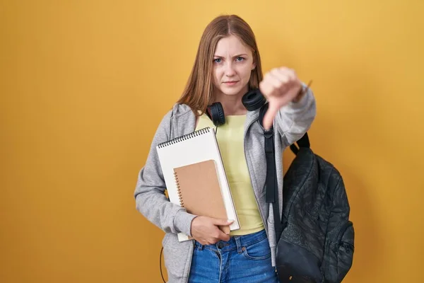 Young Caucasian Woman Wearing Student Backpack Holding Books Looking Unhappy — 图库照片