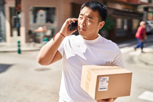 Young Chinese Man Courier Talking Smartphone Holding Package Street — Stock Photo, Image