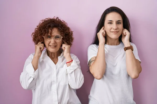 Іспанська Мати Дочка Одягнені Білу Сорочку Рожевому Фоні Закривають Вуха — стокове фото