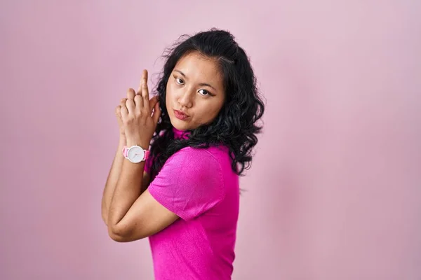 Young Asian Woman Standing Pink Background Holding Symbolic Gun Hand — Stockfoto